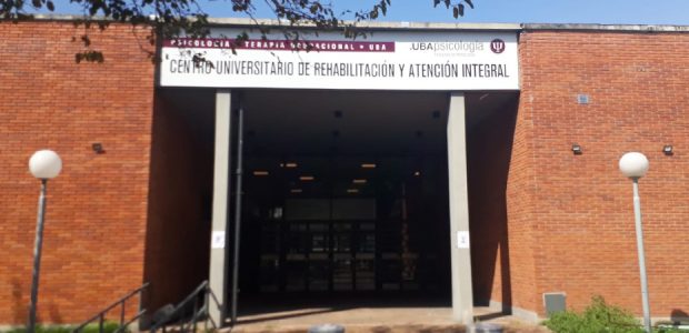 Entrance to Centro Universitario de Rehabilitación y Atención Integral, brick building with glass doors and banners above.