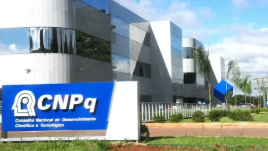 Front view of a modern glass-building with a blue CNPq sign at the entrance, Brazil's National Council for Scientific and Technological Development